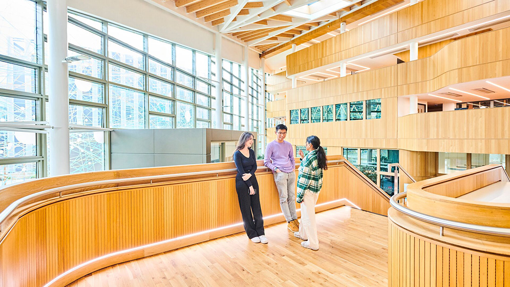 Three students chatting on the Urban Sciences Building staircase. 