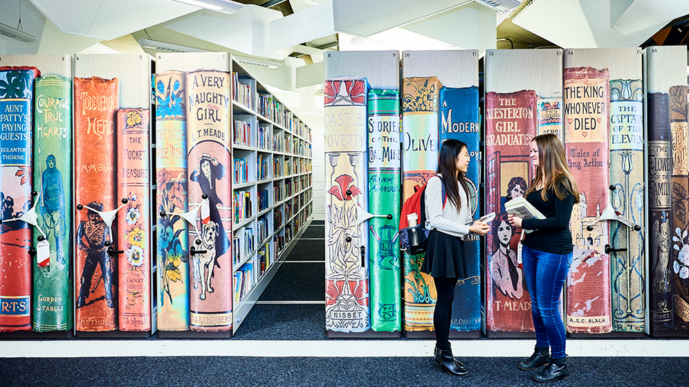 Students chatting in a library 