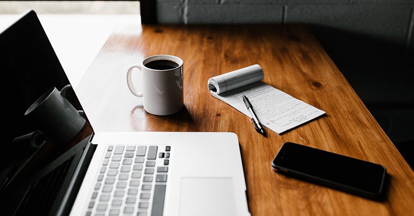 Laptop, smartphone, pad and paper set out to prepare for writing up project