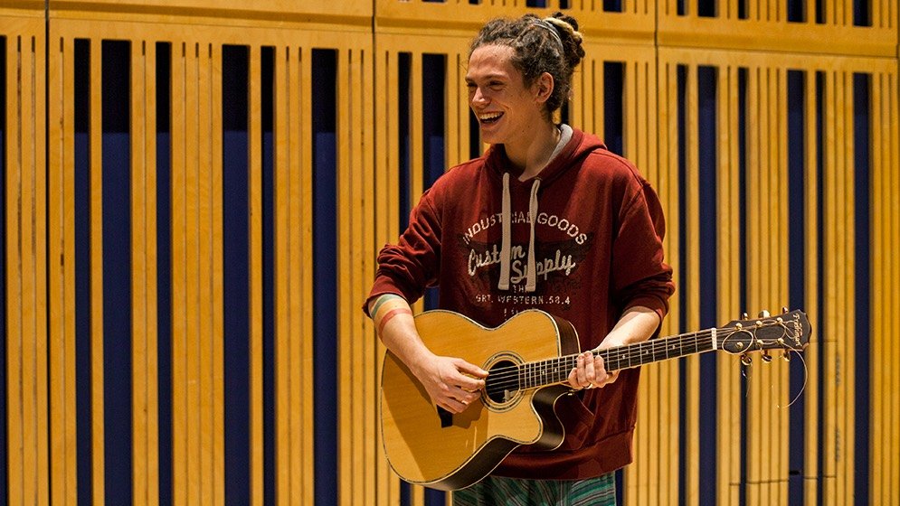 A music student performing with a guitar.
