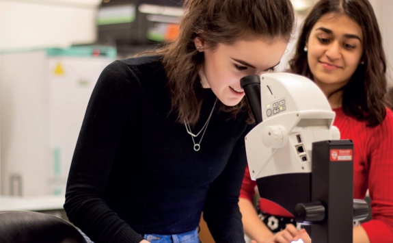 A student looking through a microscope