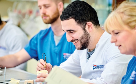 A student dentist working on some false teeth