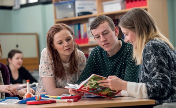 Students looking at early years learning material