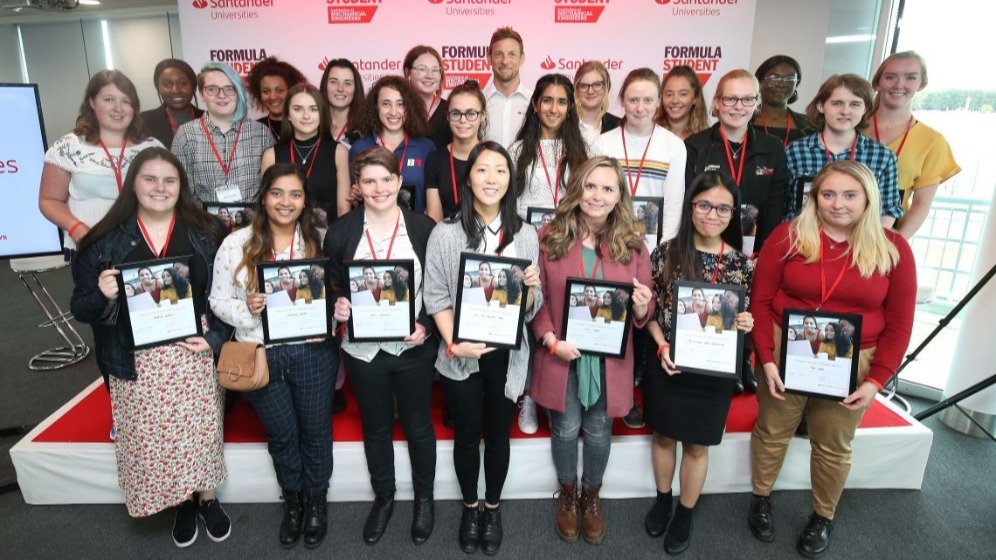 A group of women at a ceremony holding framed certificates.